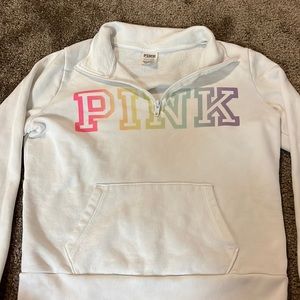 White sweater with rainbow logo.